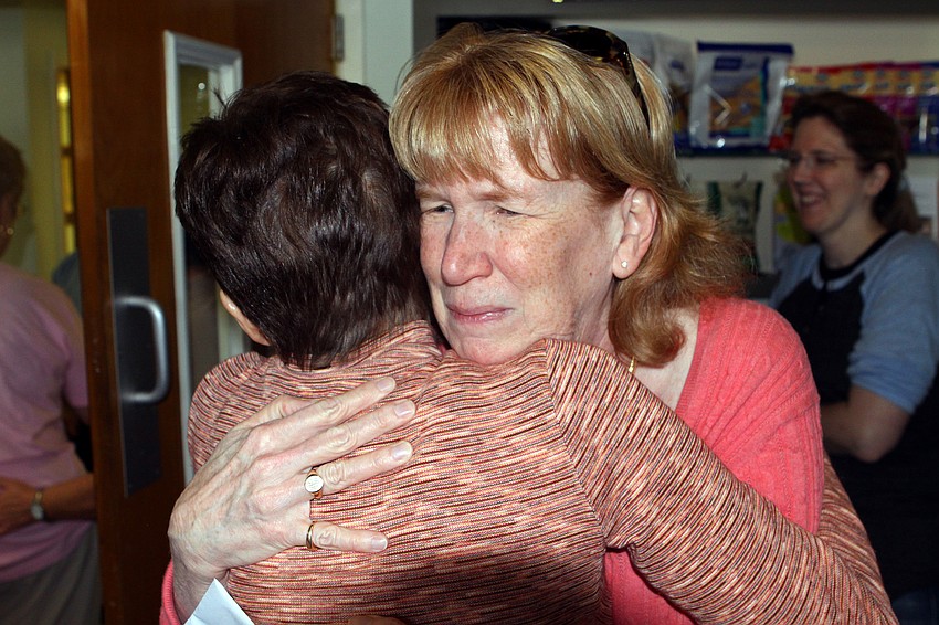 Dr. Whitlock gets a big hug from Pat Tway who has been bringing her pets to Dr. Whitlock for many years.