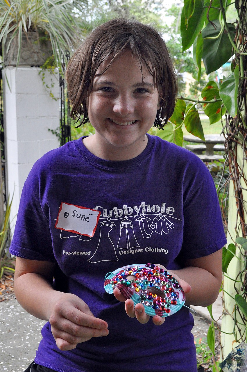 Sune Venter works on adding tons of glitz and glamour to her mask, Saturday, Oct. 29, during Family Mask Day at Artists on the Court.