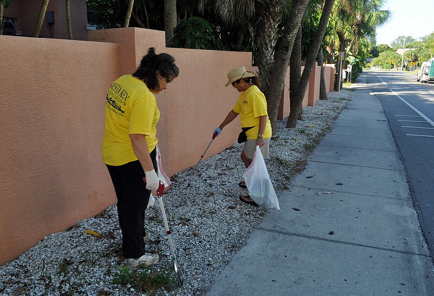 Maria Shay and Beverley Arias try to pick up as many cigarette butts as possible.