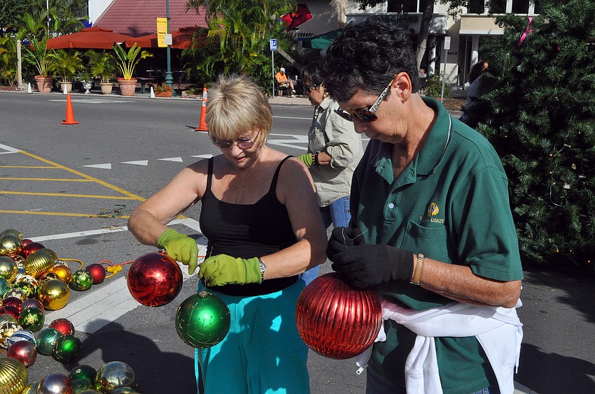 Pamela Scollay and Mary Whittington work to untangle some of the tree ornaments.