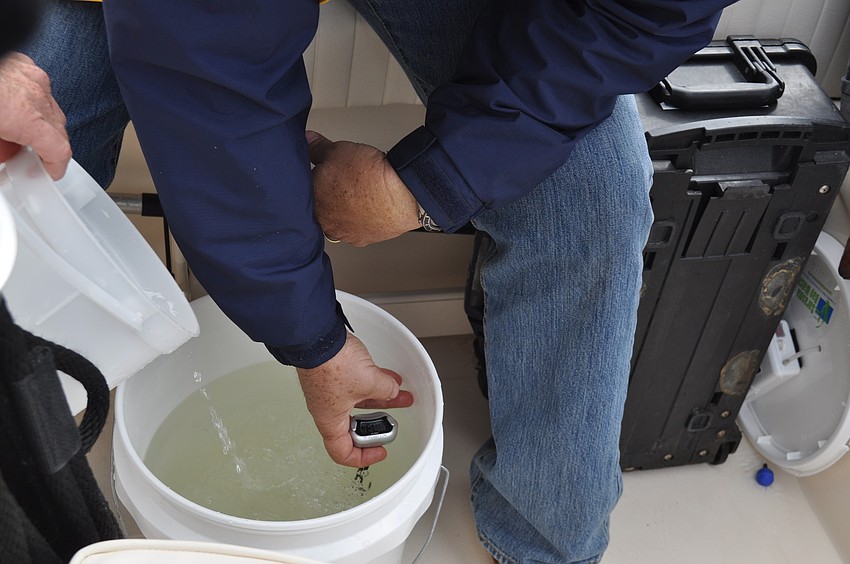 Andy Mele tests the water temperature while Chinnis slowly adds bay water to balance the temperature much like one would with a fish tank.