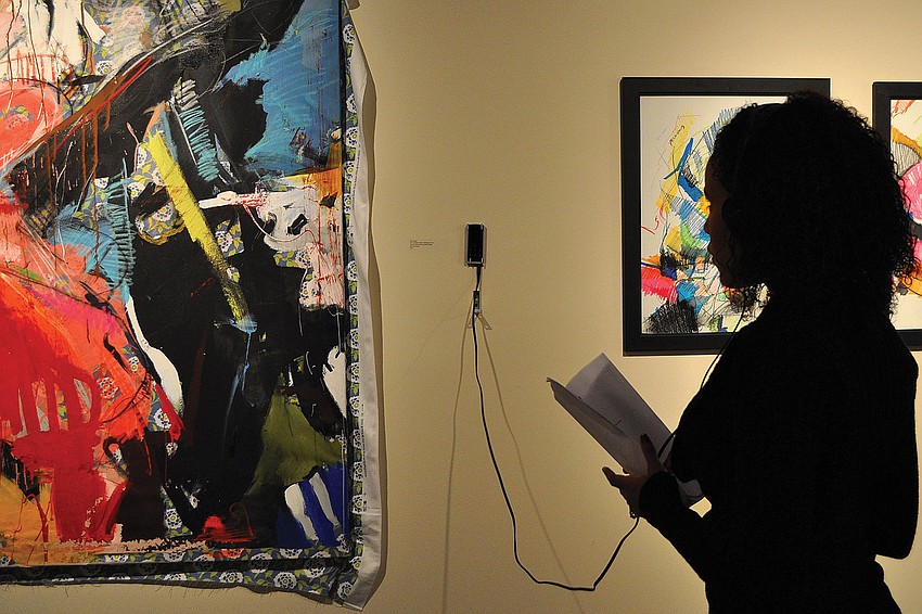Indiana Martinez examines a piece done by Tim Jaeger at s/ART/qâ€™s December opening night reception of the exhibit, 