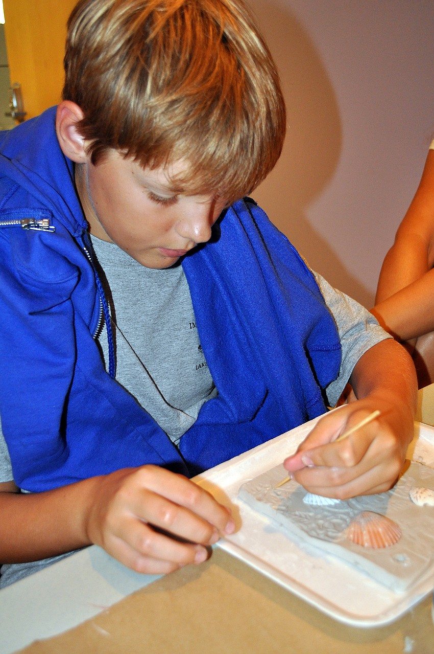 Connor Murray, 12, adds some creative texture to his clay slab.