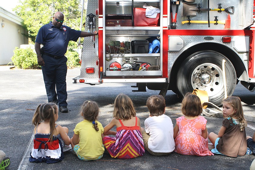 Firefighter Ricky James shows off his fire truck. One boy said he liked how red it was.