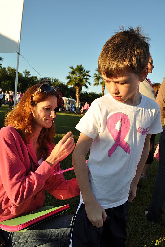 Cheri Hutchinson pins a remembrance poem on the back of Colton York, 7, in honor of her friend Kim Marsh, who died Oct. 20 of breast cancer.
