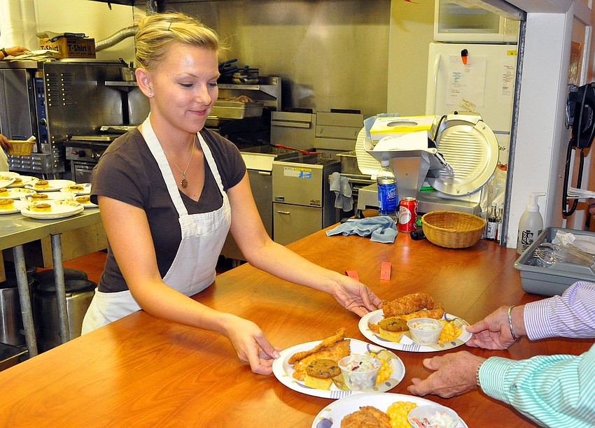 Missy Williams works hard behind the counter with her other co-workers to get out as many fish dinners as possible.