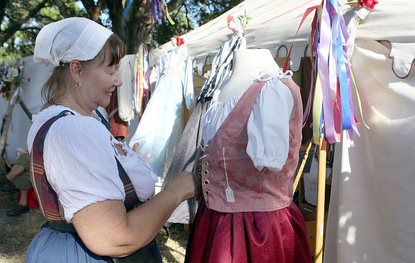 A Stitch in Tyme owner, Kathleen Lucht, puts a new outfit on her mannequin, Anne Boleyn.