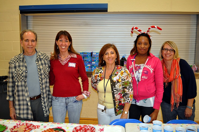 Mark Perlman, Debbie Keyso, Virginia Tafur, Turquoise Dillard and Corissa Grothe pose together behind the cookies and juice table.