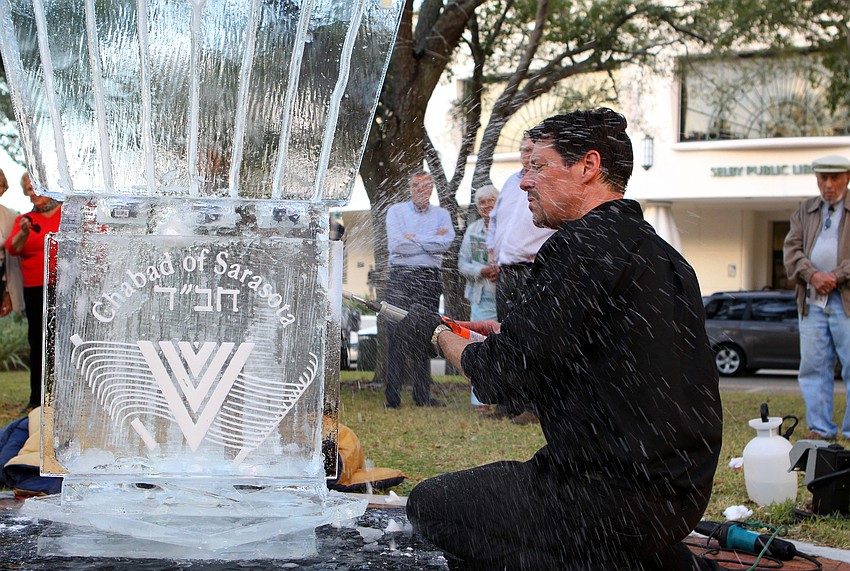 Joe Rimer puts some finishing touches on his ice menorah.