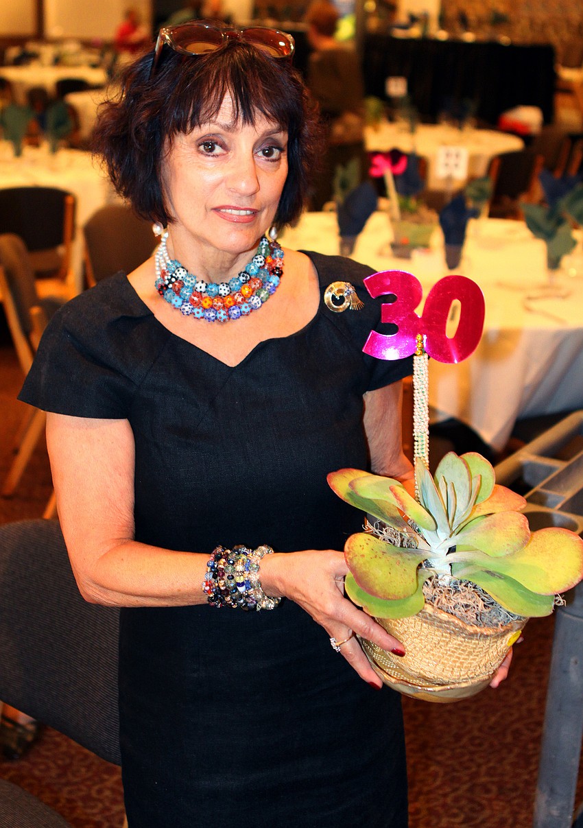 Lynnie Siegal holds up one of the pots she made that were the centerpieces on all the tables at the 30th Annual Women in Power Luncheon.