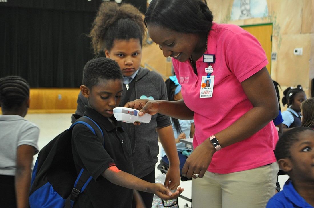 Chantell Sandy, Florida Hospital Flagler clinical educator, uses a vein finder device to help students at Bunnell Elementary School see the veins in their arms. Photo courtesy of Lindsay Cashio