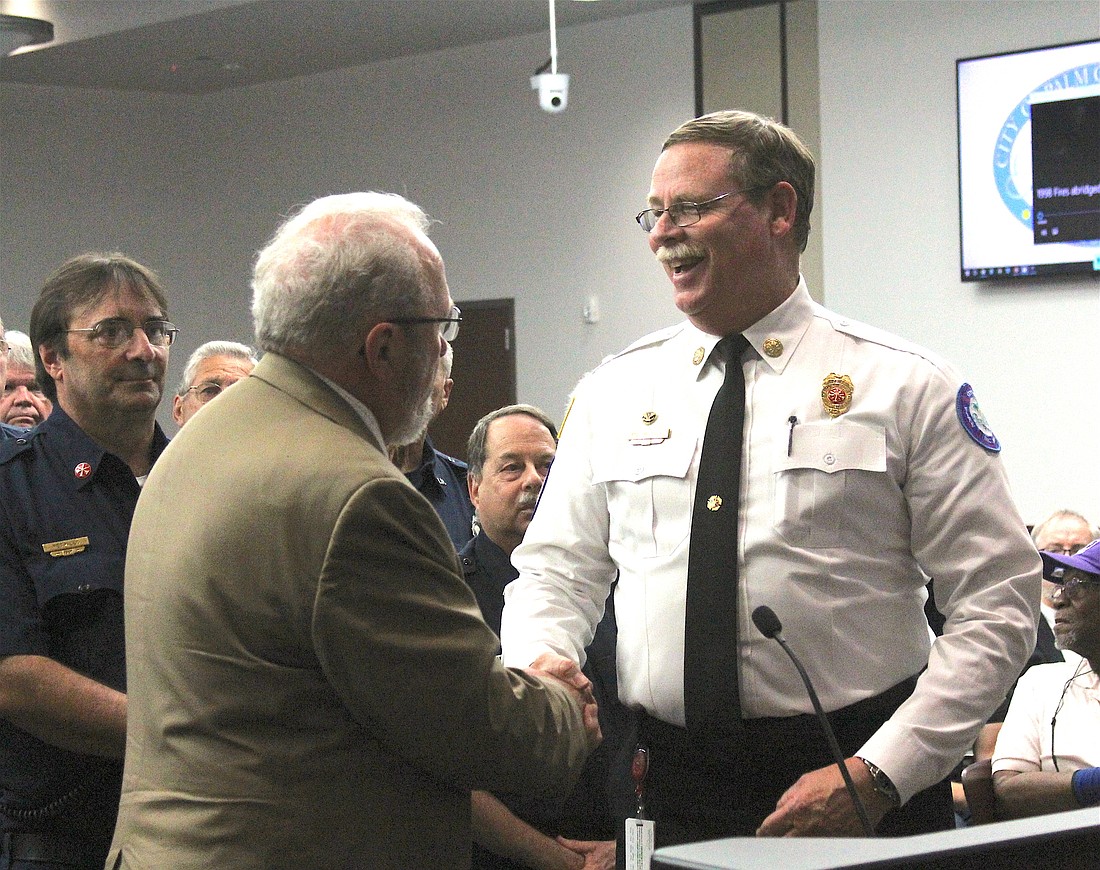 Palm Coast City Councilman Bob Cuff thanks Fire Chief Mike Beadle for the work of the firefighters from 1998 to today. Photo by Brian McMillan