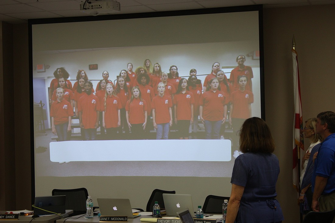 Students at Buddy Taylor Middle School sing the National Anthem for the June 5 school board workshop via a recording shown on a screen. Photo by Wayne Grant