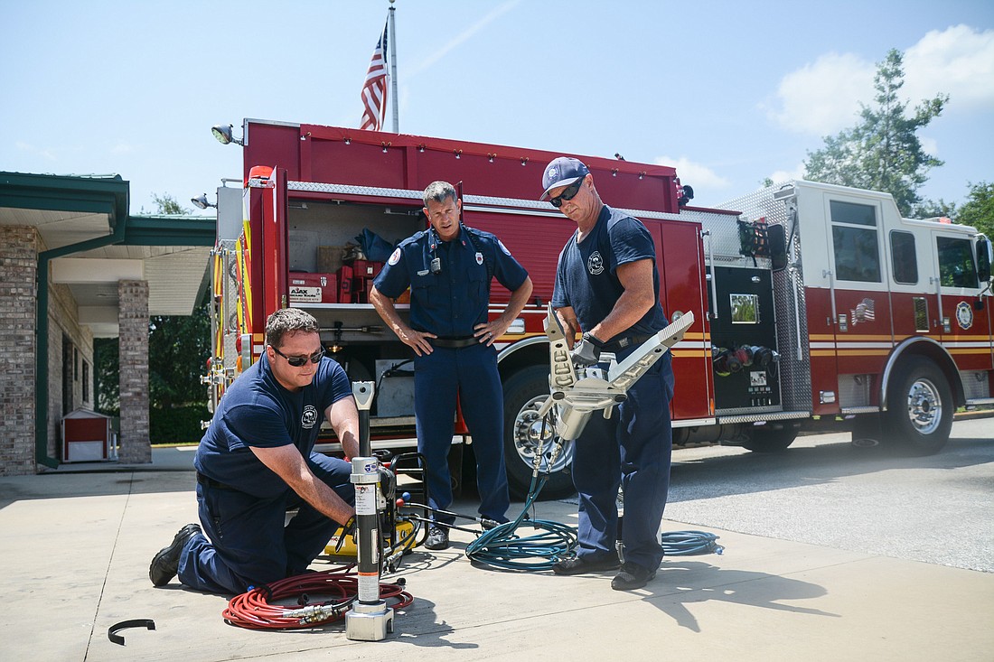 Firefighter-EMT Chris Strozier, EMT Lt. Jason Wagner and firefighter-paramedic Robert Ballou test the gear used to pry people out of cars if needed. Photo by Paige Wilson