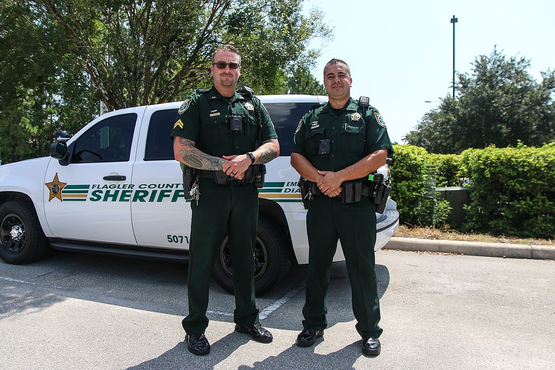 FCSO school resource deputies Cpl. William Lowe and Cmdr. Philip Reynolds pose by a squad car. Photo by Paige Wilson