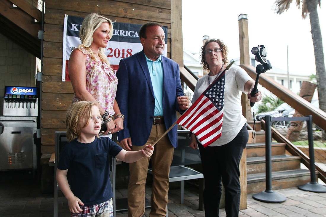 Jessie Mullins waves an American flag as Joe Mullins stands next to his wife, Jennifer Mullins, and speaks to Sarah Whedbee of localflagler.com. Photo by Paige Wilson