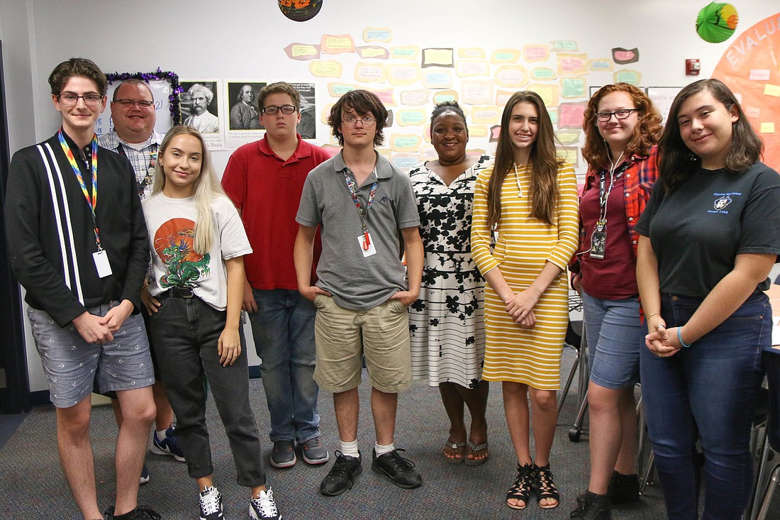 Caleb Krassner, instructor Jason Keen, Jordan Hess, Shawn Boardman, Lucas Cooper, instructor Kimberly Keen, Sarah Malinowski, Margaret Stitz and Gabby Dennany pose for a photo during a writing club meeting. Photo by Paige Wilson