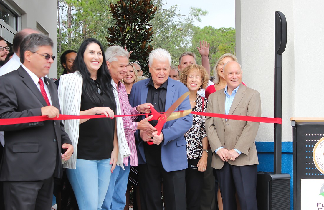 Co-owner Don Gioia cuts the ribbon at the ceremony for the opening of the facility's Palm Coast location. Photo by Ray Boone