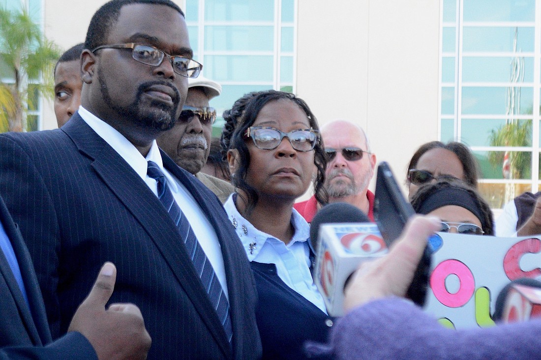Kimberley Lee, center, speaks to the press Dec. 18.  Her husband, Travis Lee, is at left. (Photo by Jonathan Simmons)