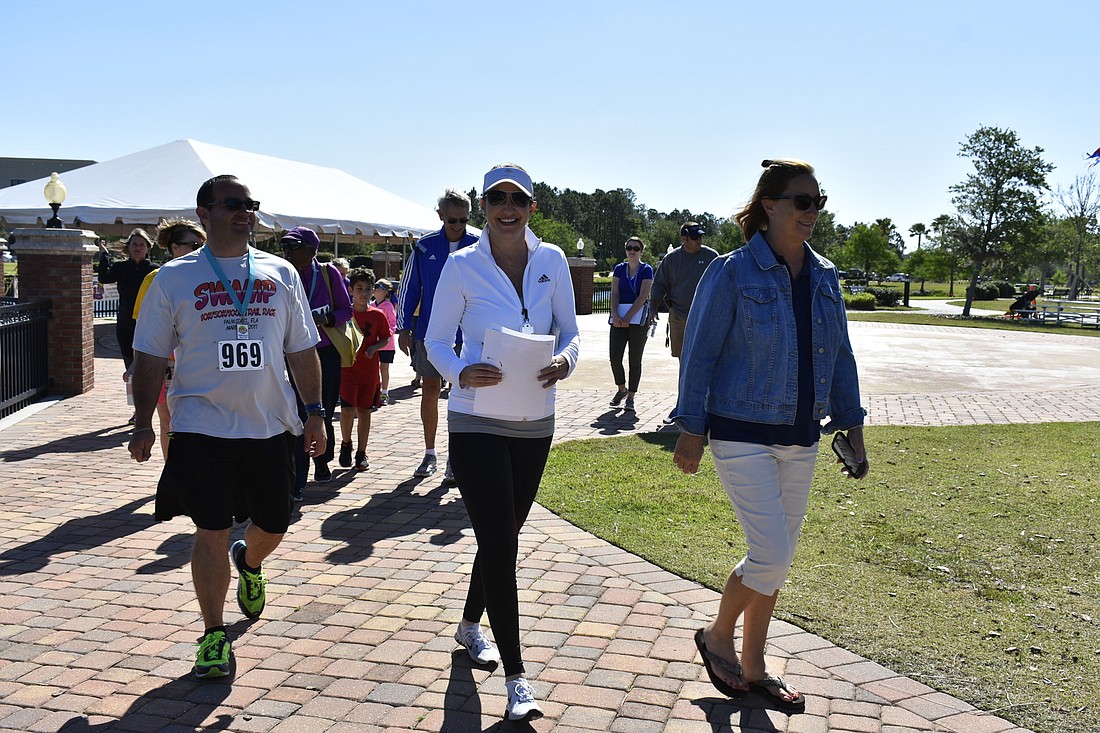Palm Coast Mayor Milissa Holland, center, and Flagler Beach Mayor Linda Provencher, right, lead a walk around Central Park in Town Center. It's time for the next Mayor's 90/90 Challenge. Photo courtesy of the city of Palm Coast