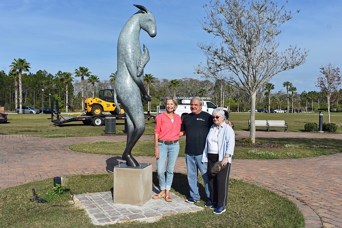 Artist Copper Tritscheller, left, and Tom Gargiulo and Arlene Volpe of the Gargiulo Art Foundation stand by €œBurro with Bird on Shoulder' on installation day. Photo courtesy of the city of Palm Coast
