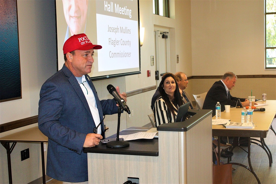 Flagler County Commissioner Joe Mullins speaks as Palm Coast Mayor Milissa Holland looks on at a recent business town hall on the future of Internet access. His cap says, €œFocusing on Flagler." Photo by Wayne Grant