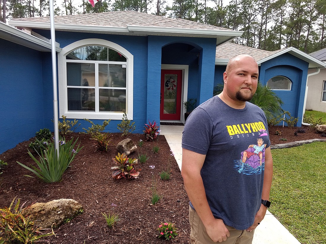 Bryan Denker said his house was painted a blue color with an LRV of 15, which is one row of paint tiles too low on the Sherwin-Williams display. It was his mistake, but he says the city is too strict. Photo by Brian McMillan