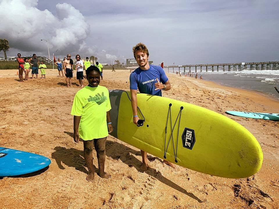 Volunteer Dalton Dalecki with a Surf Camp attendee. Photo courtesy of Marketing2Go