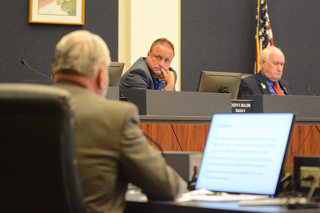 County Commissioner Joe Mullins listens to comments by County Administrator Jerry Cameron, at left. Commissioner David Sullivan is at right. (Photo by Jonathan Simmons)
