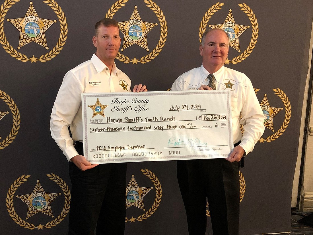 Flagler County Sheriff Staly (right) presents the check to Charlotte County Sheriff Bill Prummell, chairman of the FSYR. Photo courtesy of FCSO