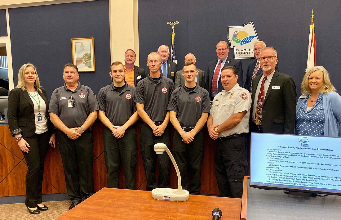 New firefighters Noah Dunaway, Beau Kruithoff and Dylan Cronk with Chief Don Petito, school district staff and county commissioners. Photo courtesy of the Flagler County government