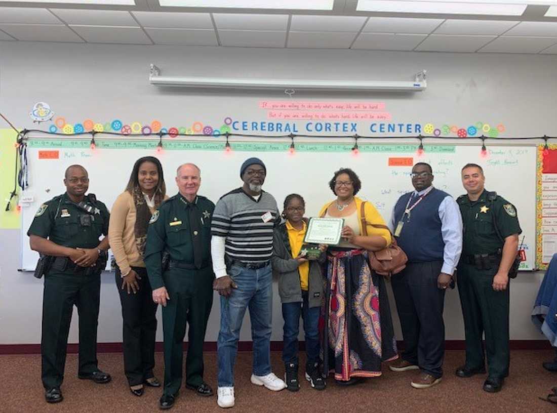 Deputy Robin Towns, Rymfire Elementary School Principal Mrs. Moore, Sheriff Rick Staly, D'Zyon Coates with  family, Rymfire Elementary School Assistant Principal Mr. Lee, and Commander Phil Reynolds. Photo courtesy of the FCSO