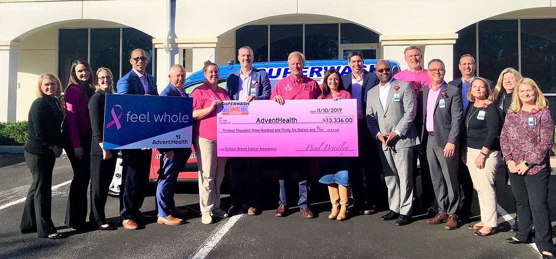 Employees from SuperWash and AdventHealth hospitals at a check presentation. Courtesy of AdventHealth