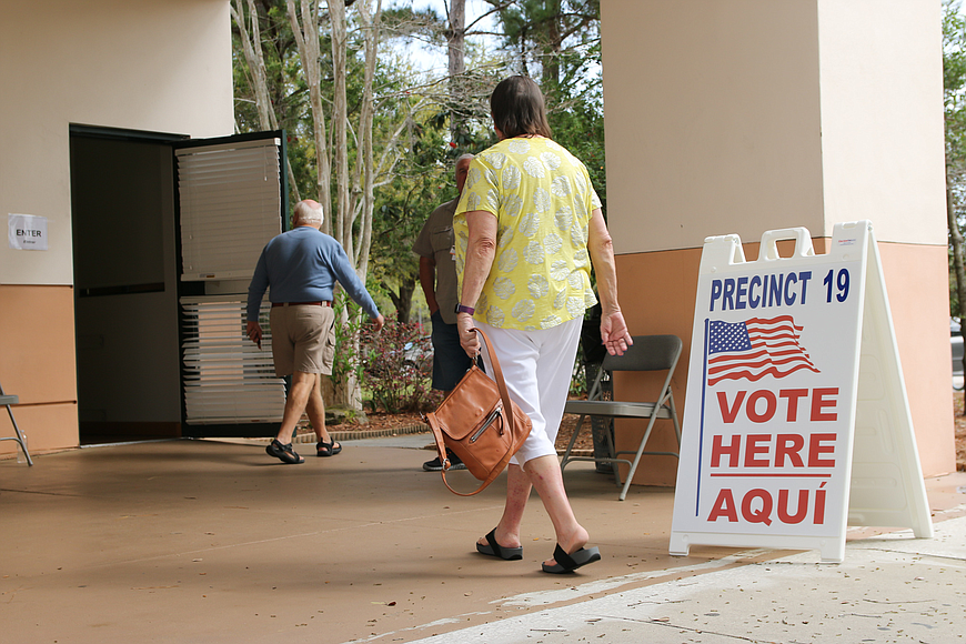  Voters walk into and out of the precinct at the Flagler County Public Library. Photo by Ray Boone