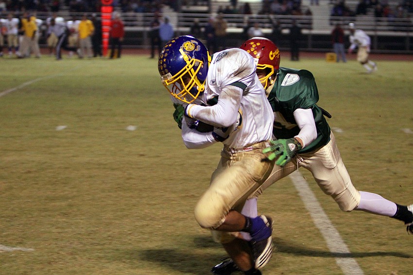Rick Pecorelli, 81, tackles Alex Mobley, 15, during the 20th Annual Brad Price Memorial PAL Bowl, Friday, Jan. 6, at Booker High.