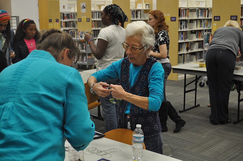 Roselyn Leon helps make jewelry at the craft station.