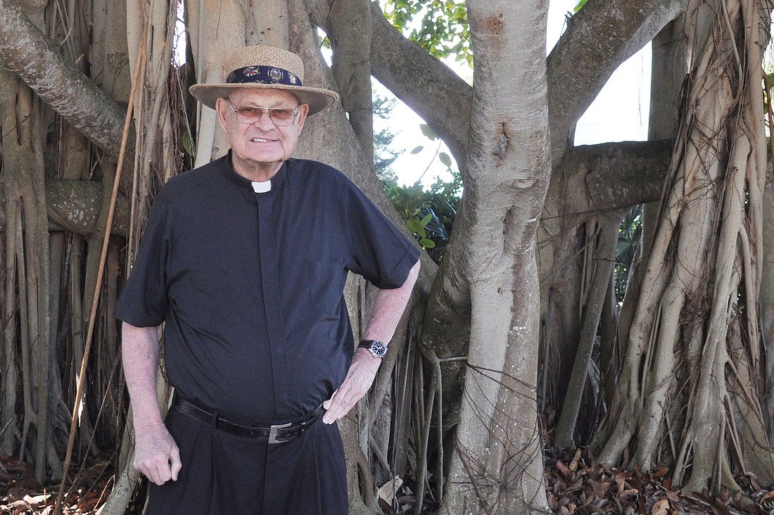 The Rev. Edward Pick, pastor emeritus at St. Mary, Star of the Sea, Catholic Church, stands in front of his favorite banyan tree.