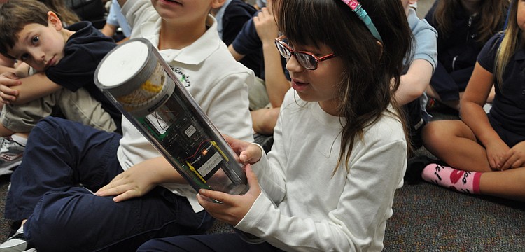Willis Elementary School first grade student Grace Haddock checks out an instrument used by the National Oceanic  and Atmospheric Administration when it sends crews to fly into hurricanes.