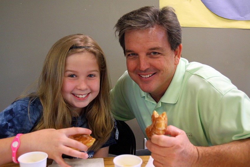 Maddy Hanewich, 9, enjoyed having donuts with her dad, Tim, Friday, Jan. 13, at Imagine School's 