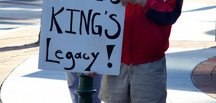 Ed Gall, 91, of Sarasota, holds up a sign that reads "Violence Insults King's Legacy!", Monday, Jan. 16, Martin Luther King, Jr. Day, at the downtown round-about.