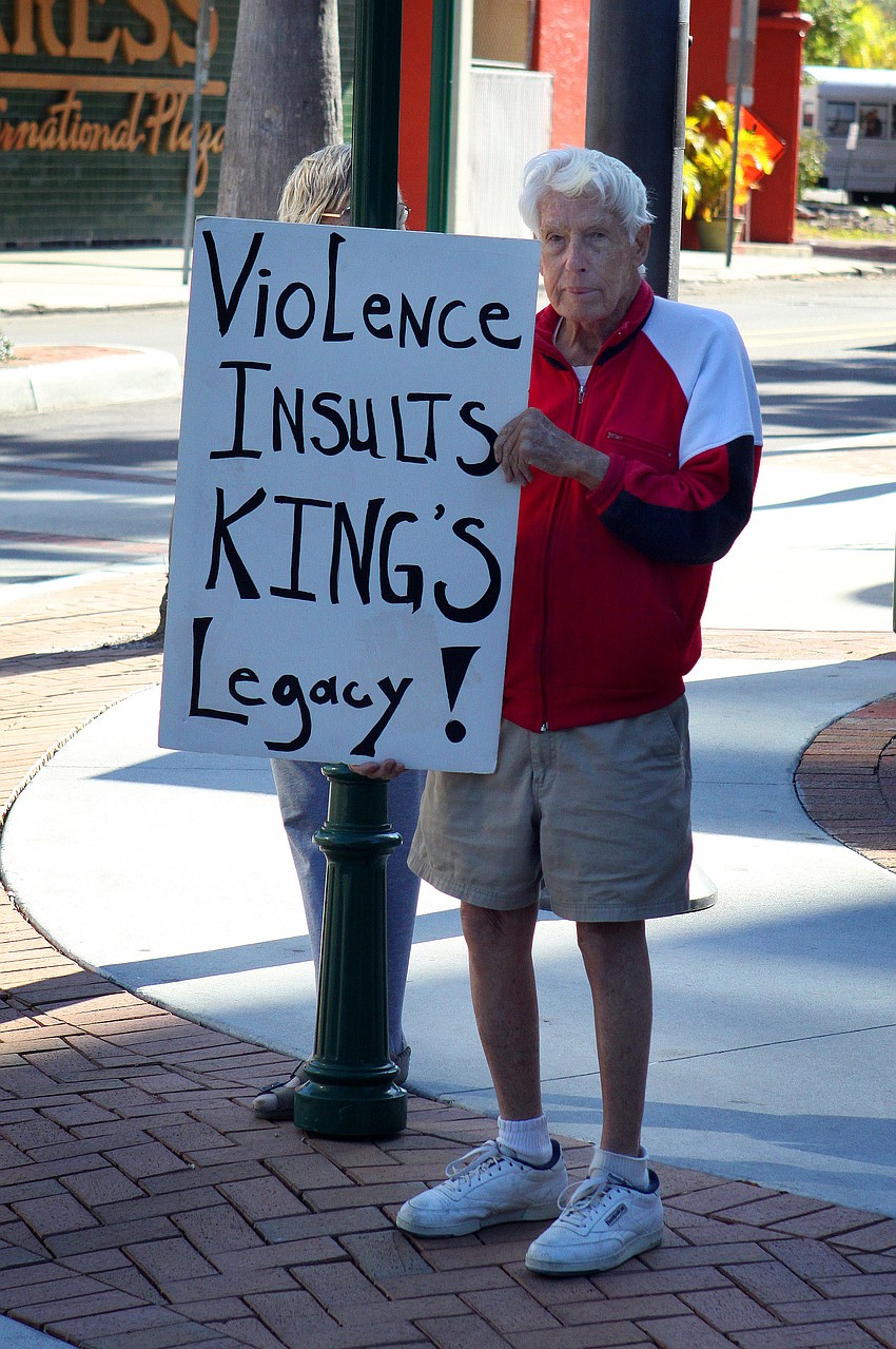 Ed Gall, 91, of Sarasota, holds up a sign that reads 
