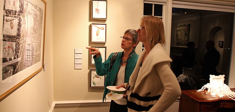 Melanie Dutoit and Muff Calderon look at Tom Stephenses photo, "Grand Entrance", Friday, Jan. 13 at the opening reception of S/ART/Q's Avant Garden at the Marie Selby Botanical Gardens.