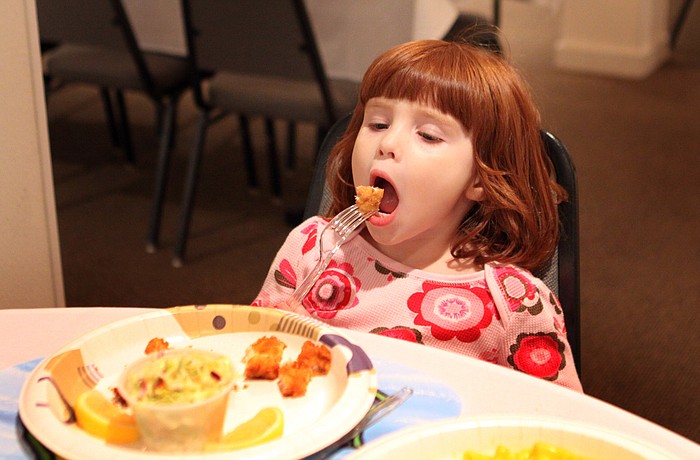 Natasha Antoniuk, 3, gets ready to eat a bite of fish.