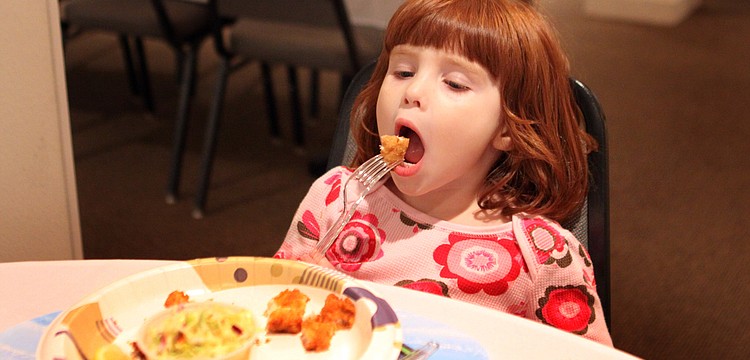 Natasha Antoniuk, 3, gets ready to eat a bite of fish.