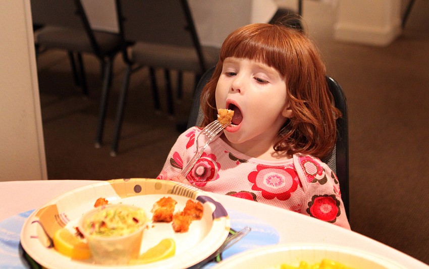 Natasha Antoniuk, 3, gets ready to eat a bite of fish.