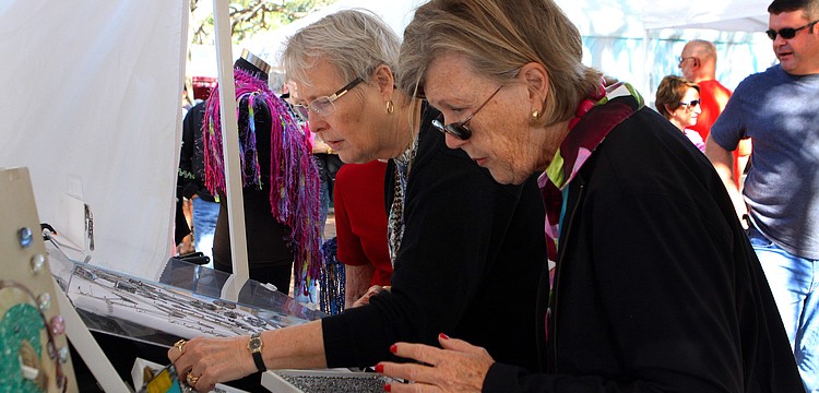 Diana Guth and Pat Coville look at some jewelry, Saturday, Jan. 28, during the 14th annual Downtown Sarasota Art in the Park at Five Points Park.