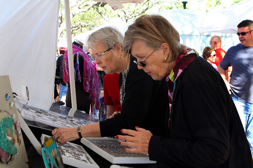 Diana Guth and Pat Coville look at some jewelry, Saturday, Jan. 28, during the 14th annual Downtown Sarasota Art in the Park at Five Points Park.