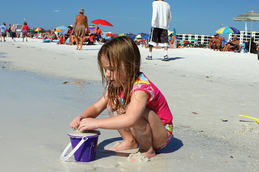 Jayna Hertlein, 3, enjoys filling her bucket with sand as she prepares to make a sandcastle Feb. 1 on Siesta Key Beach.