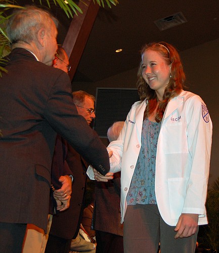 First-year medical student Morgan Pyne, of Bradenton, received congratulations from Dr. Thomas Quinn after receiving her white coat. Pyne is a graduate of Lakewood Ranch High School. Photo by Michael Polin.
