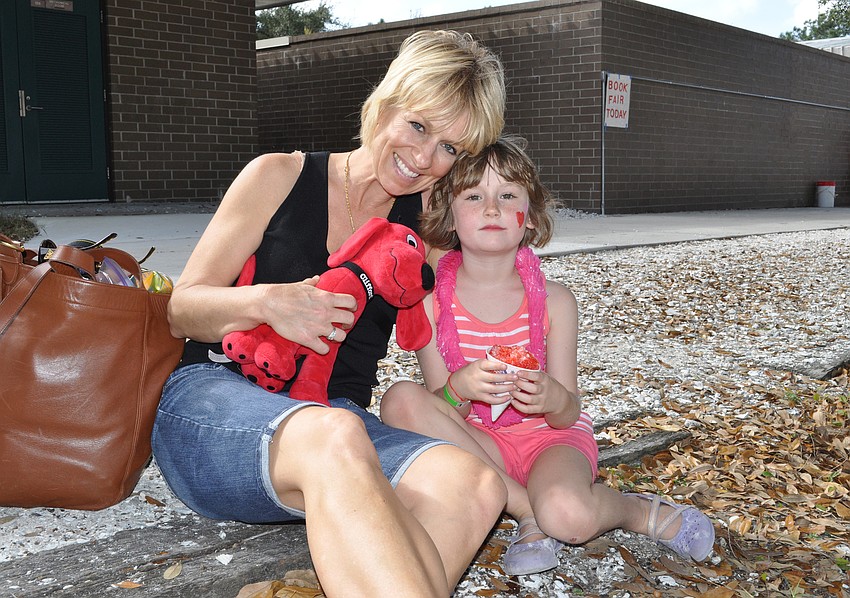First-grader Ava Robbins, pictured with her mom June, loved playing on the bounce houses. â€œTheyâ€™re fun,â€ she said.